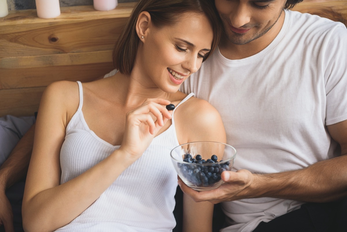 close up of a pair eating blueberries.