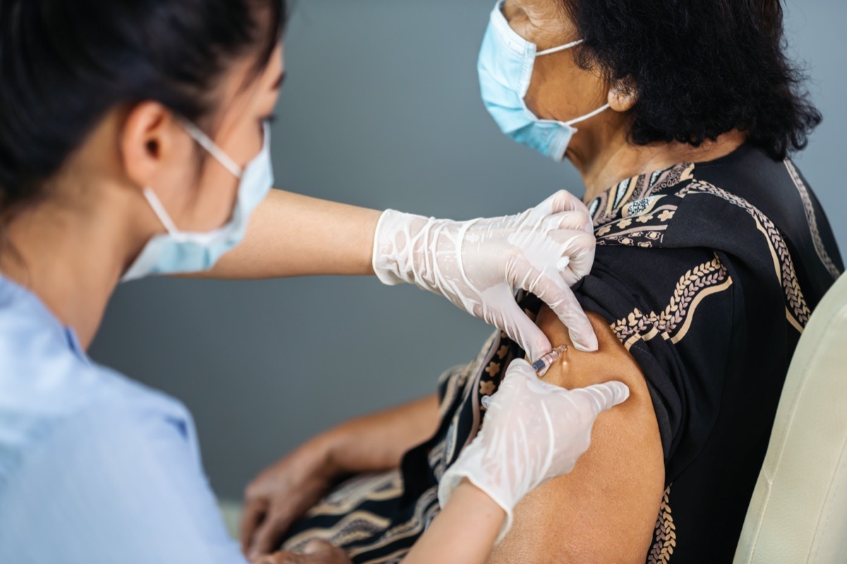 young doctor giving patient covid vaccine