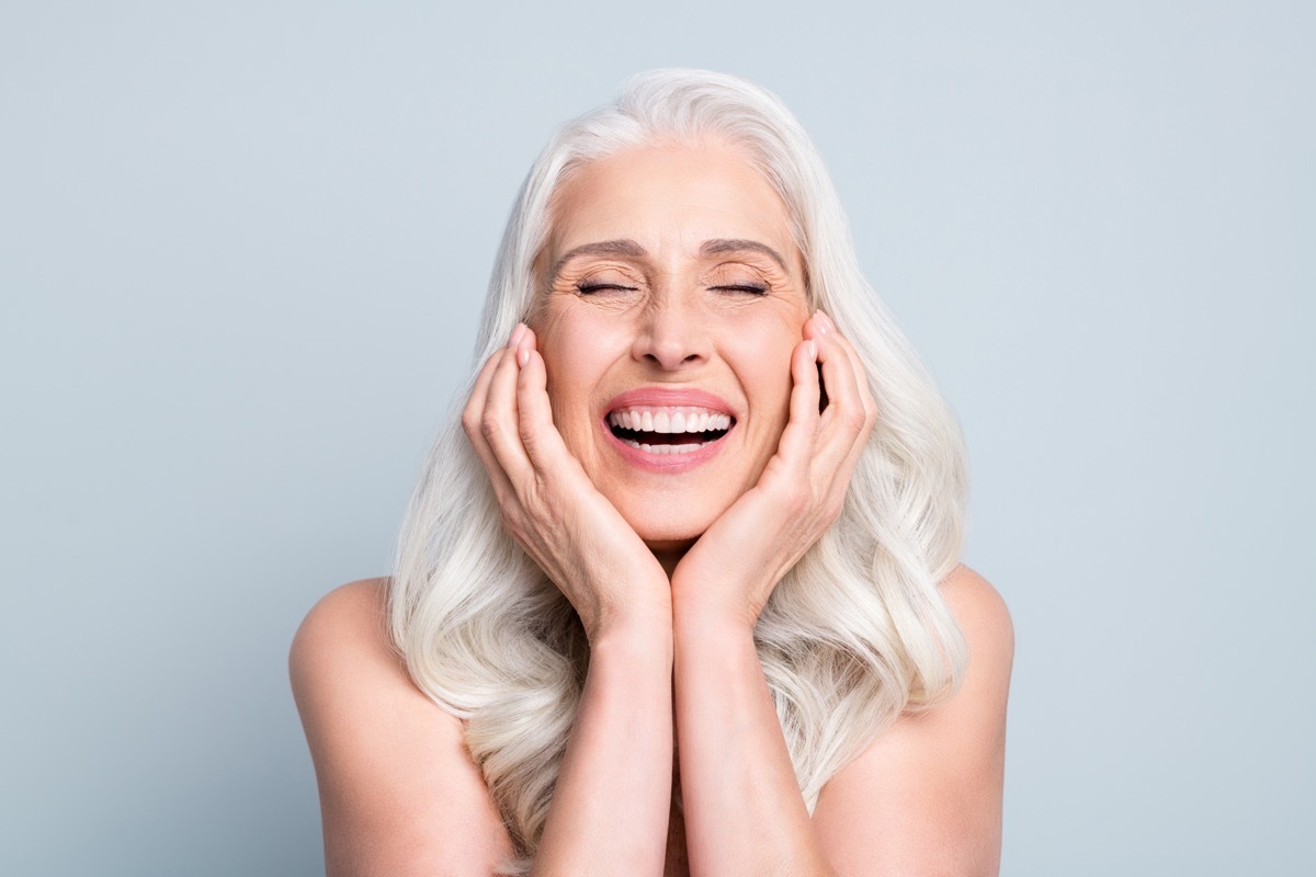 Woman with gray hair laughing.