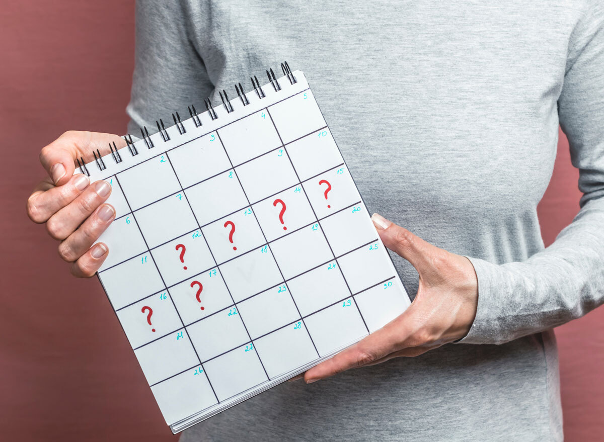 Woman holding up calendar showing late period