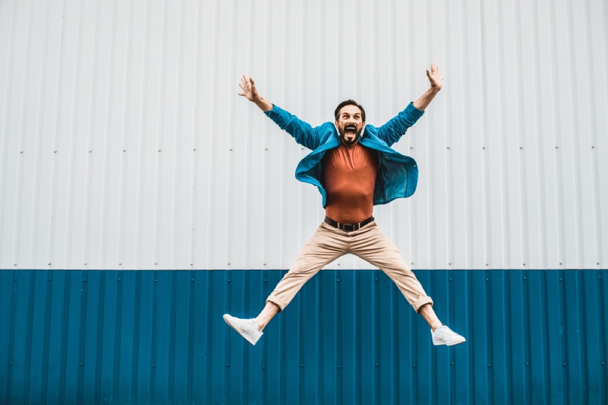 white man jumping for joy outside