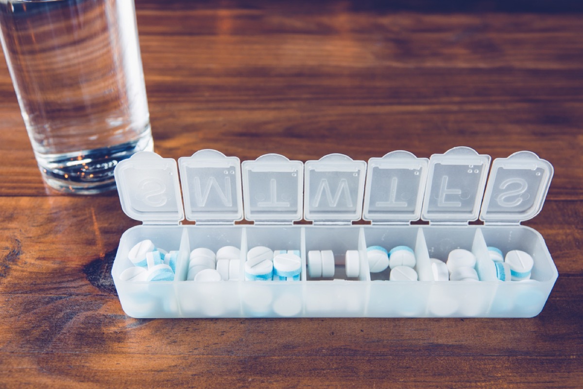 pill box on table with glass of water