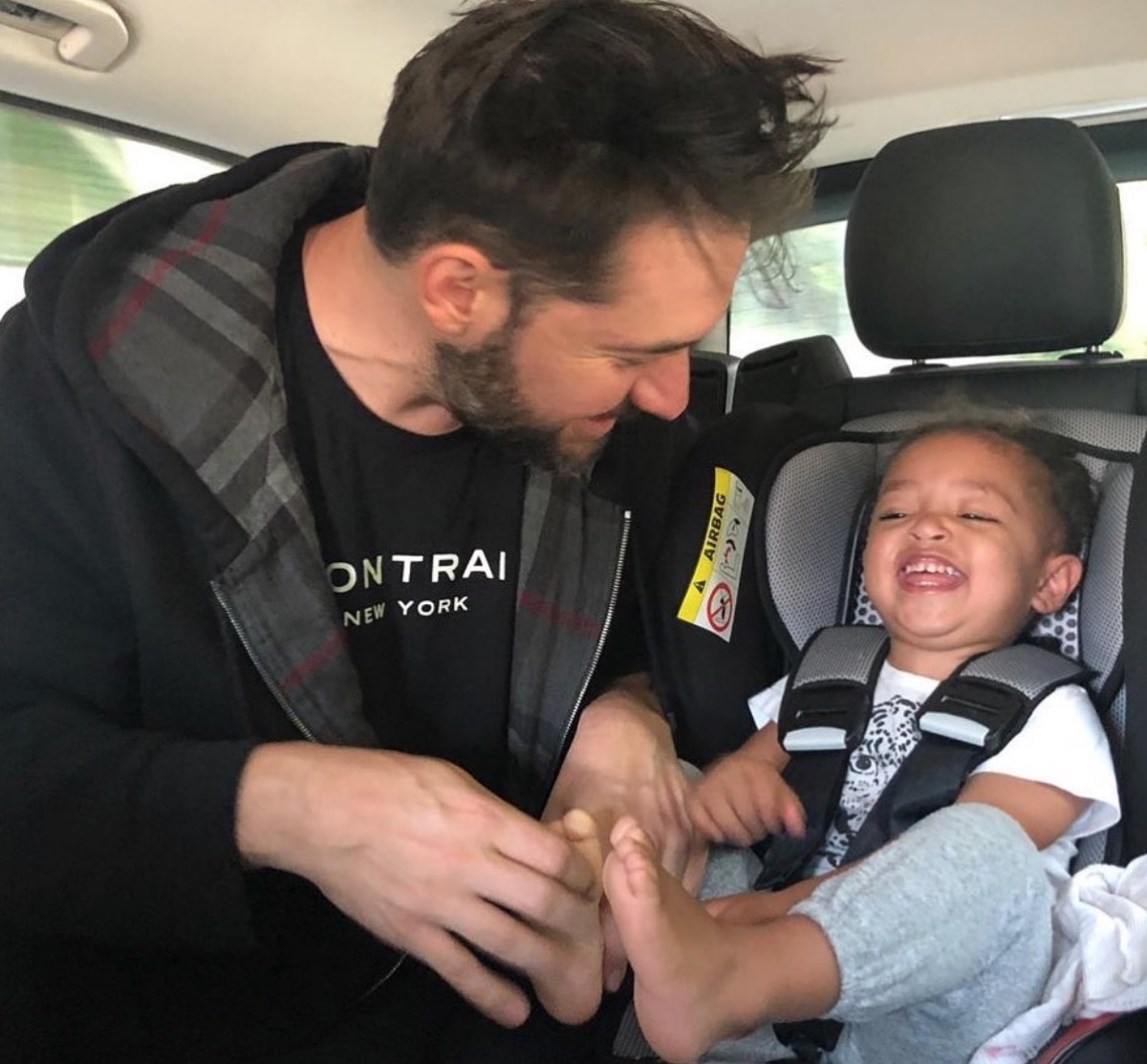 alexis ohanian tickling daughter's toes as she sits in carseat