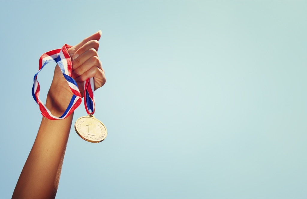 Woman at the Olympics holding a gold medal