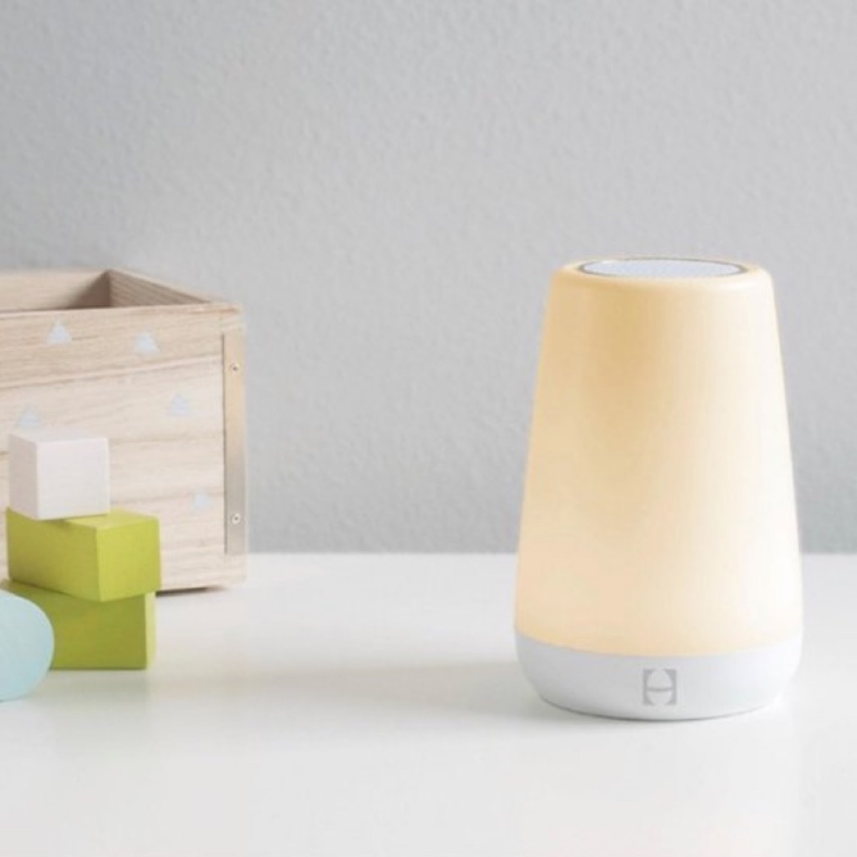 yellow night light and wooden box on white counter top