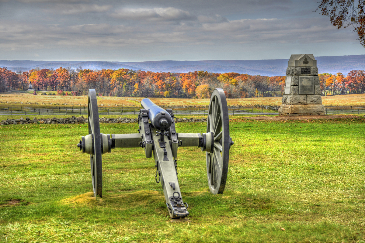 A cannon in the foreground with the fall foliage of Gettysburg, Pennsylvania in the background