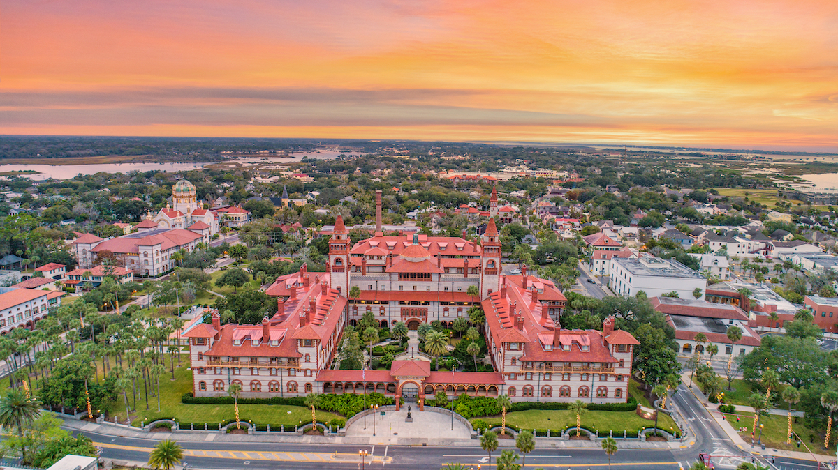 An aerial view of historic St. Augustine, Florida at sunset, showing the Lightner Museum.