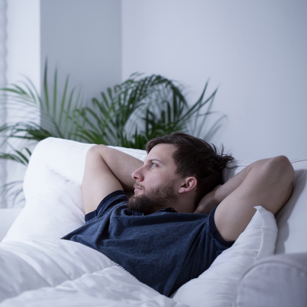 man laying in bed, ways your body changes after 40