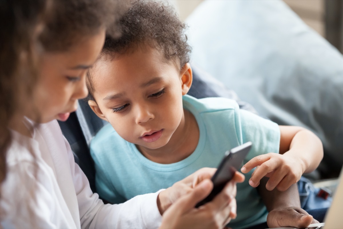 children using smartphone together at home