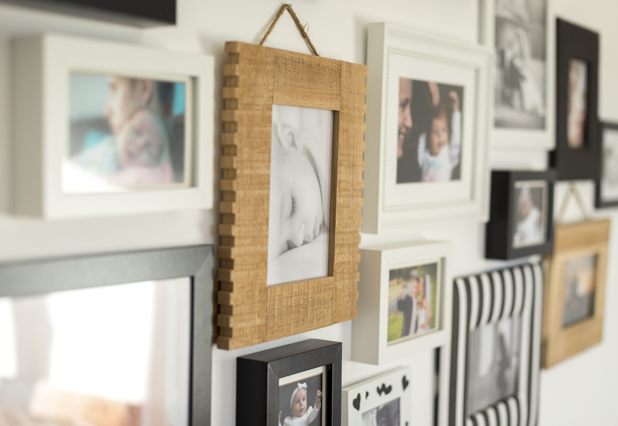 white wall with photos of the family in various photo frames