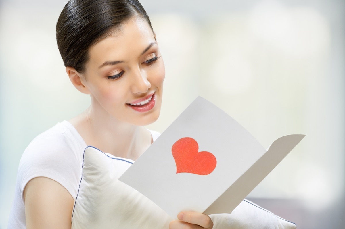 woman holding a card with a heart on it in her hand