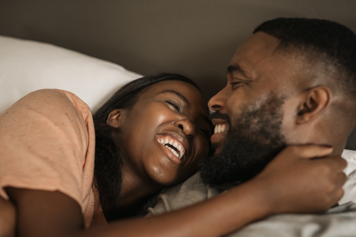 Happy black couple cuddling in bed