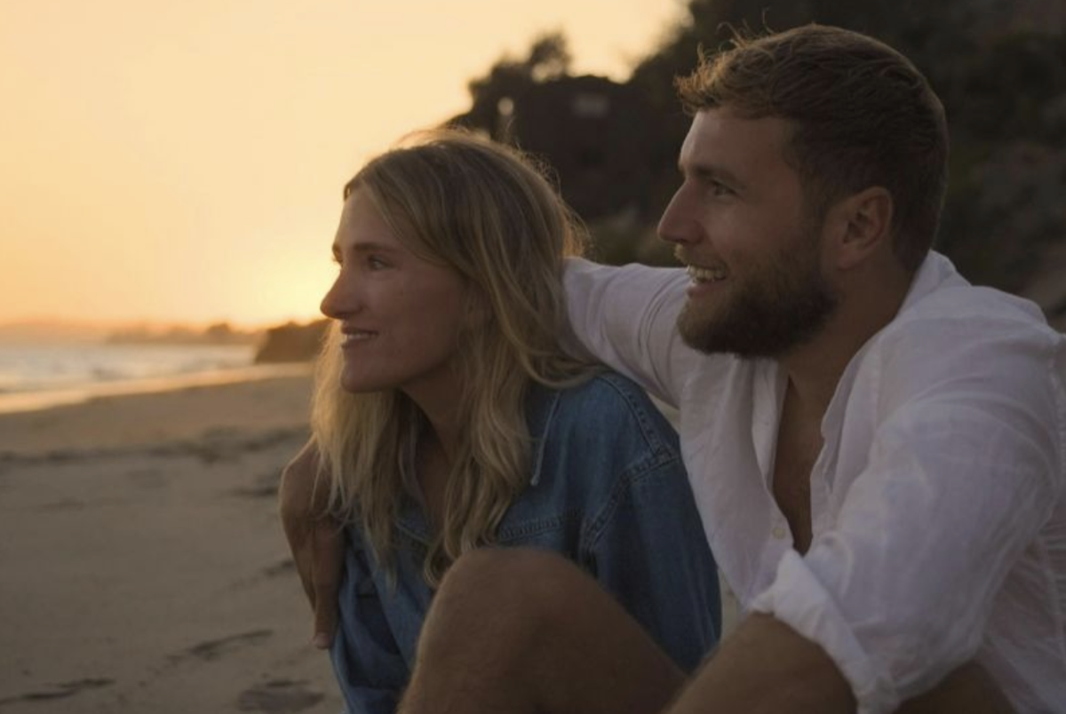 Suzan and Freek sitting together on a beach.