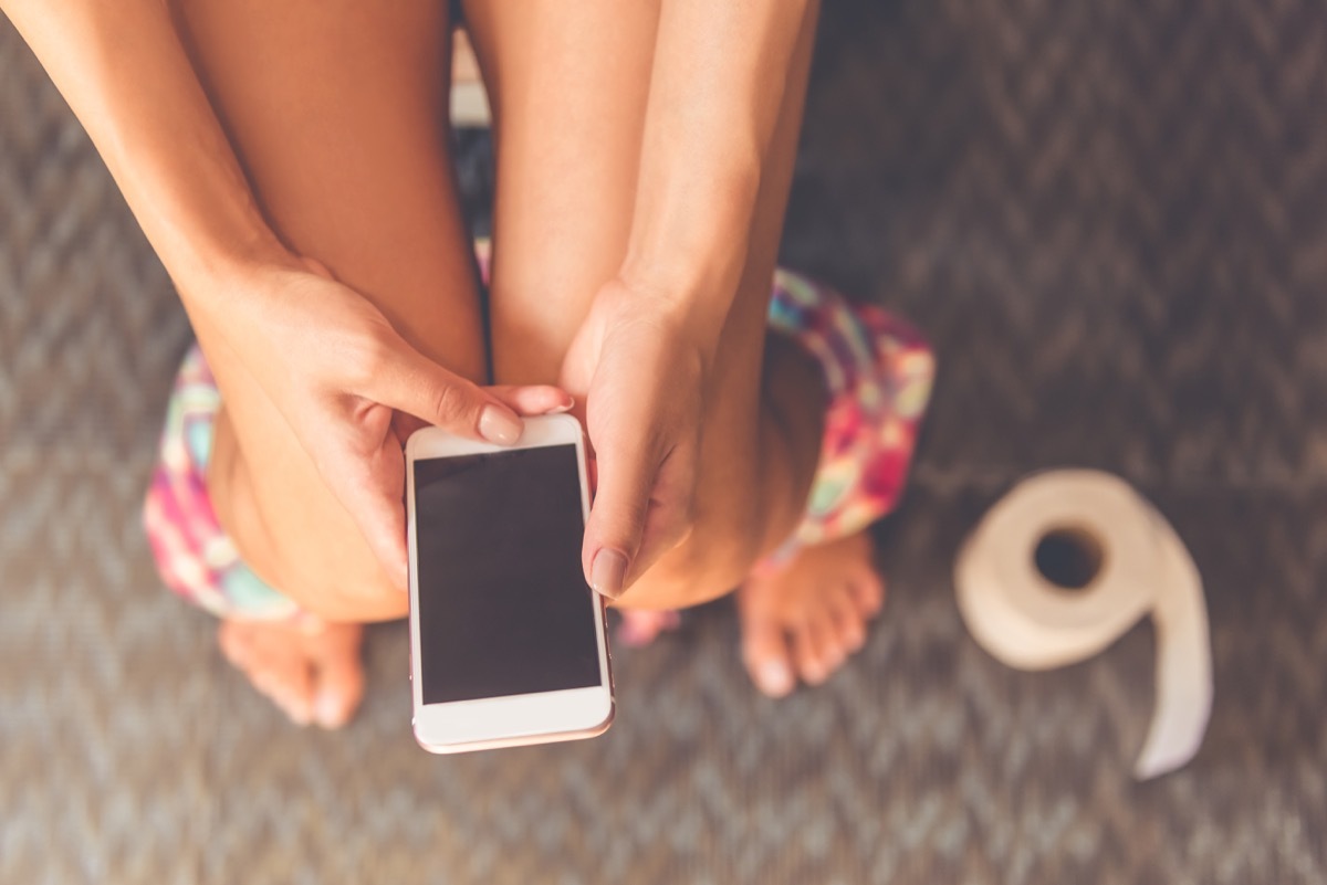 woman using phone on toilet gross everyday habits