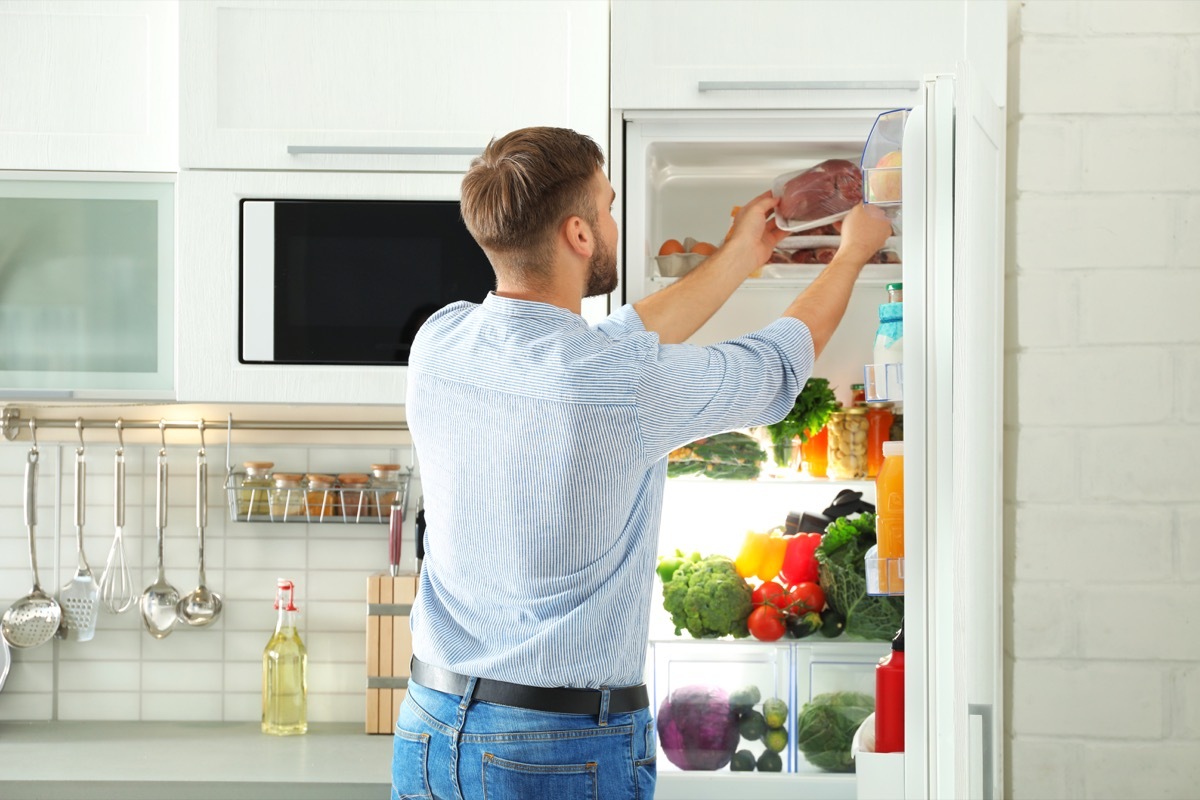 Man taking meat from fridge