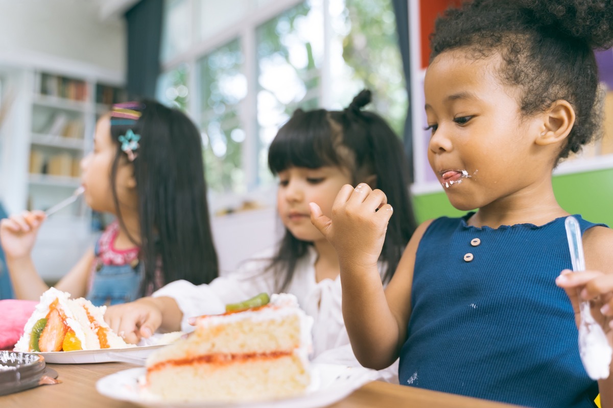 a bunch of children eating cake