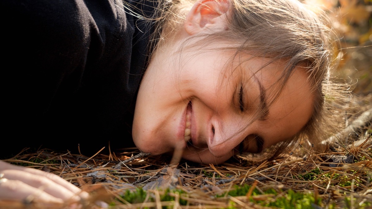 young woman with her ear to the ground