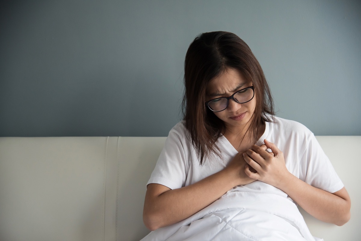 woman having heart attack on her bed. copy space.