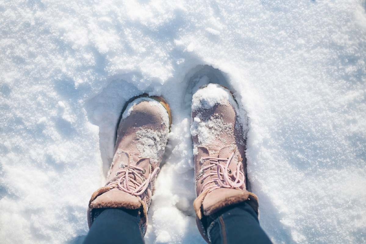 woman walking in snow in pink boots