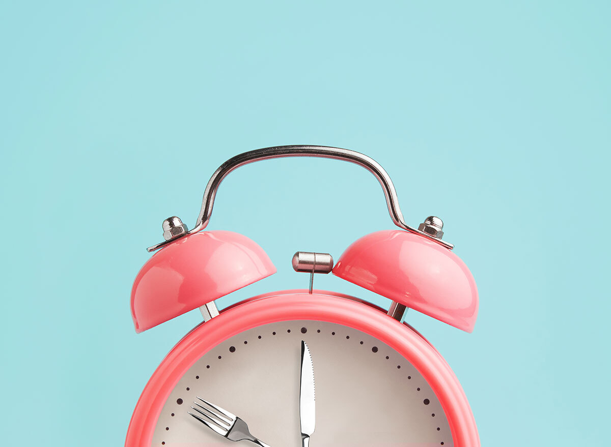 pink alarm clock on blue background