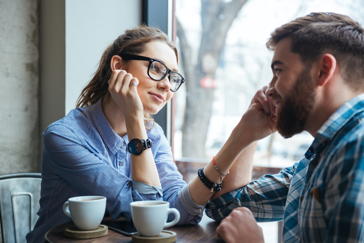 Portrait of young beautiful couple on a date drinking coffee in cafe