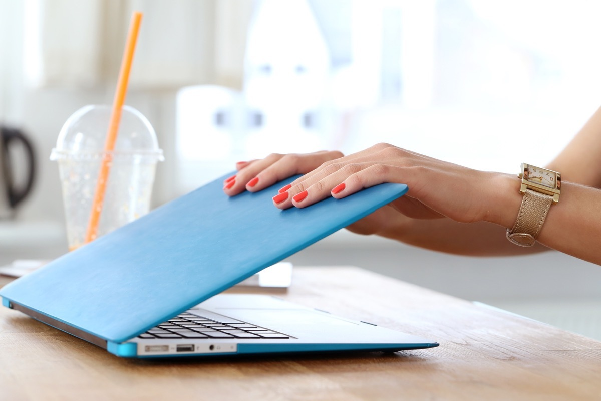 close up of woman's hands closing computer