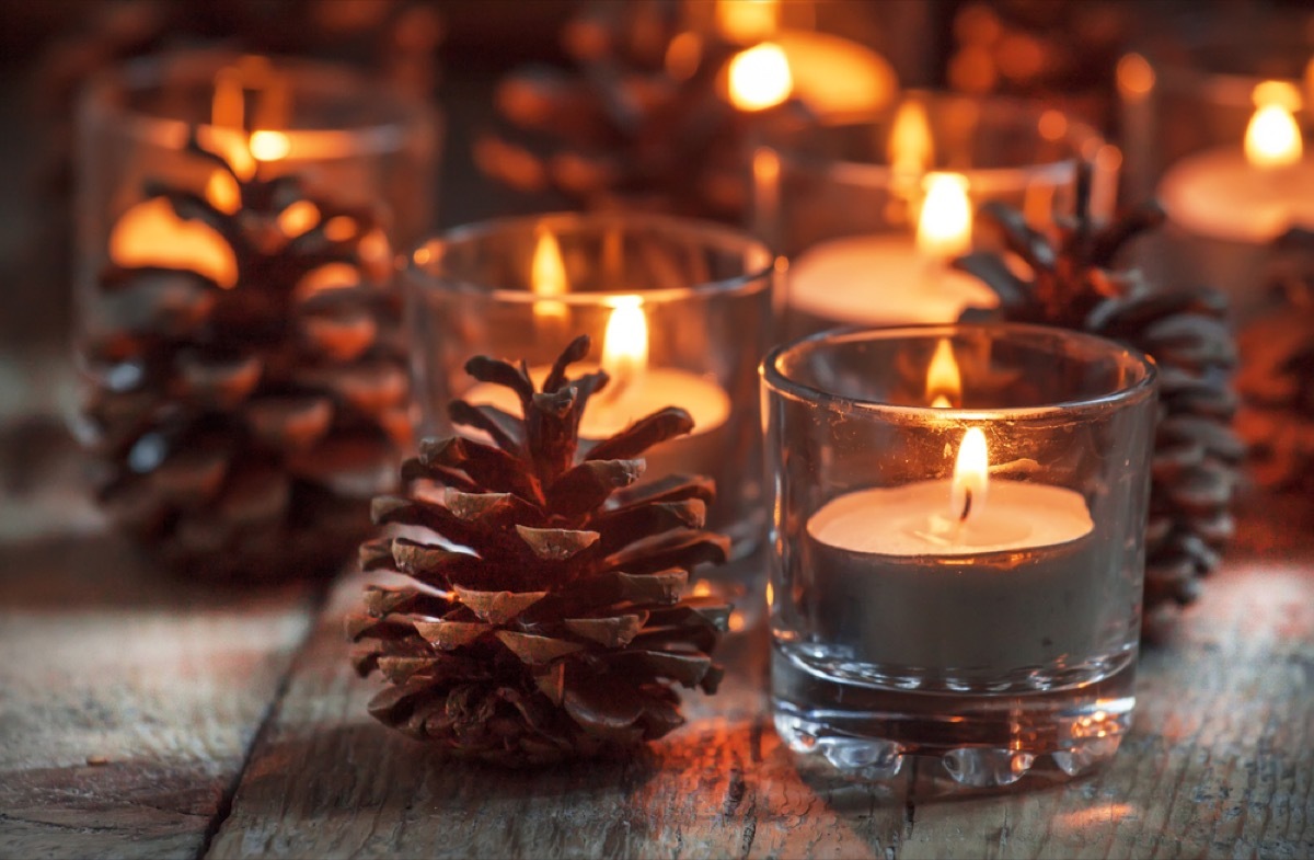 pine cones next to small glass containers full of tea lights