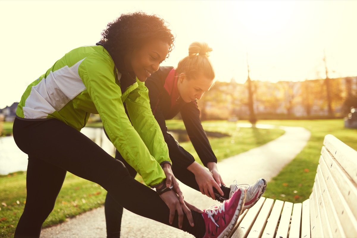 Women stretching before a run through a sunny park