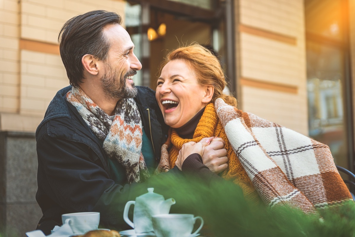 Woman laughing in a man's arms