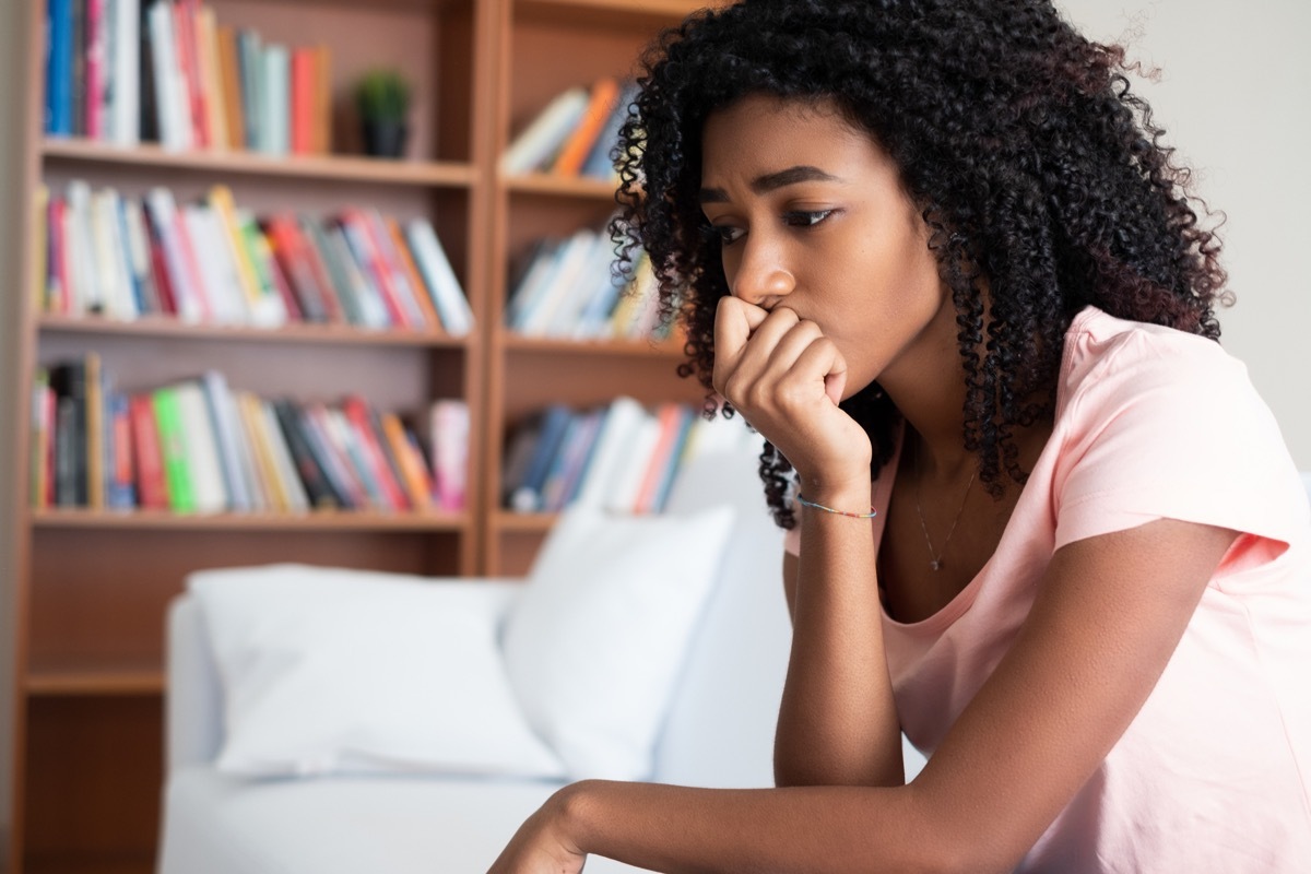 Anxious girl sitting on couch