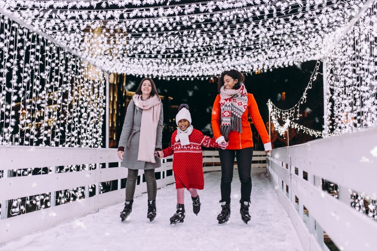 Mothers ice skating with daughter