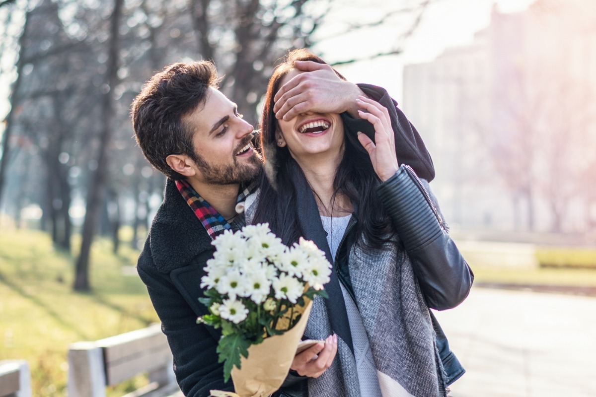 young couple laughing with flowers