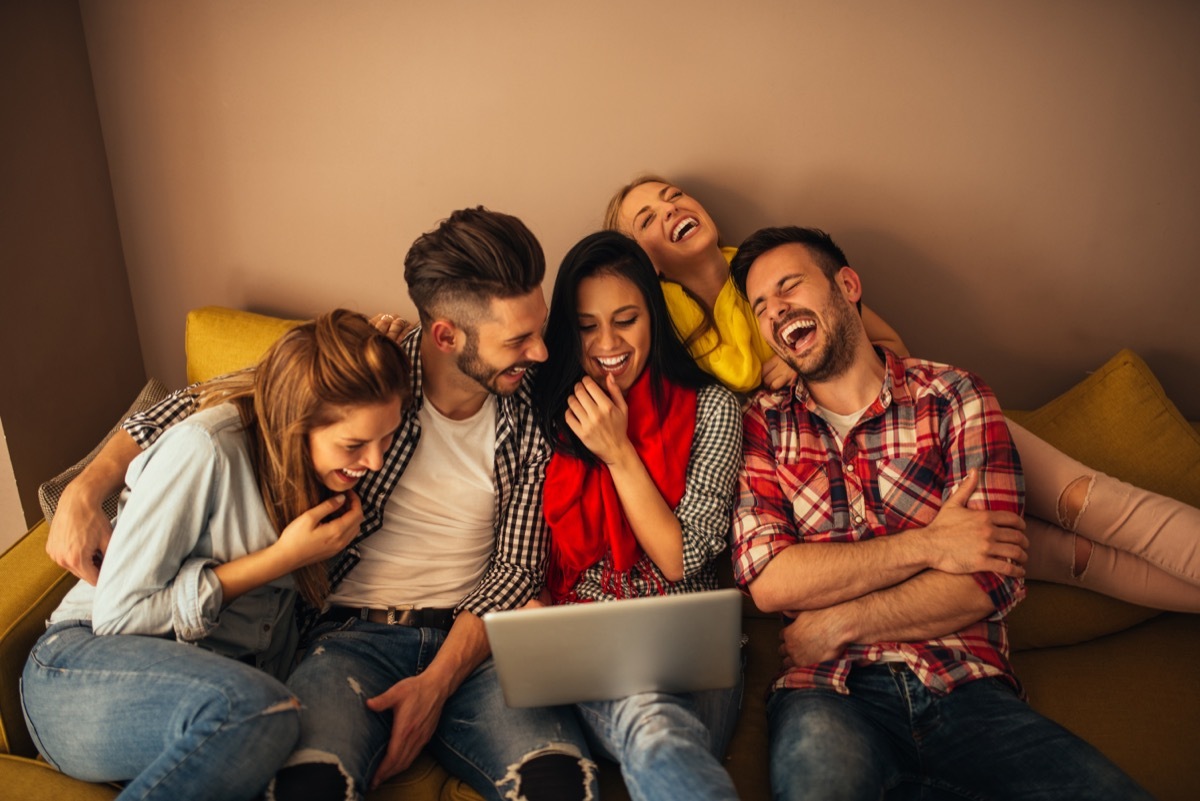 group of friends watching a movie on a laptop