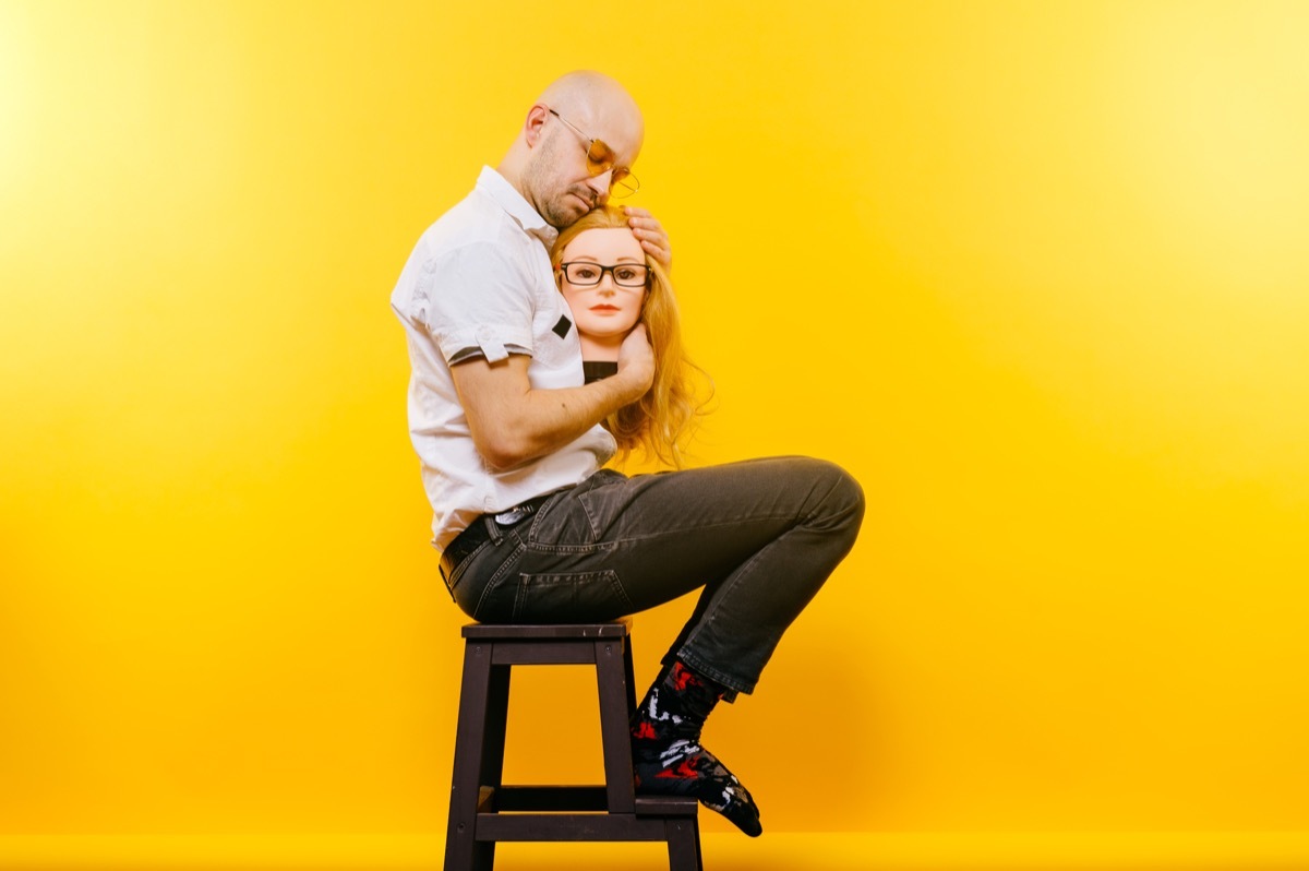 Man Cuddling a Doll Head Funny Stock Photos