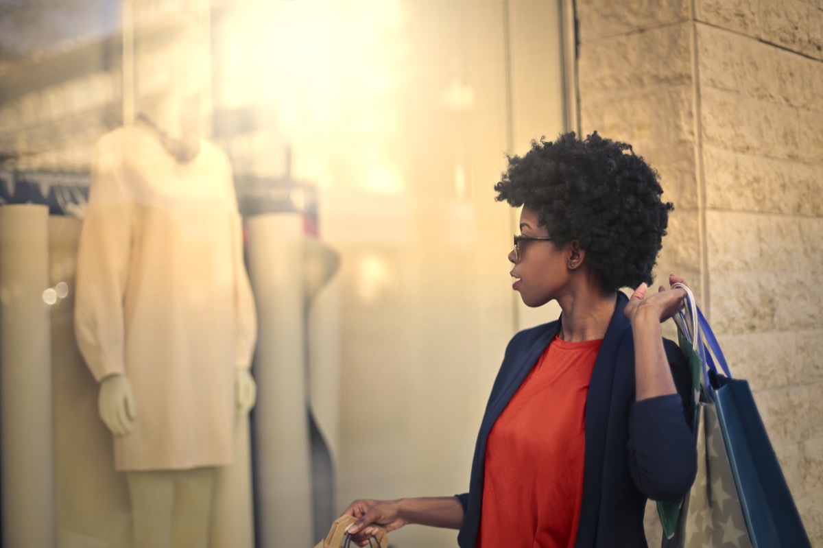 young black woman looking in store window