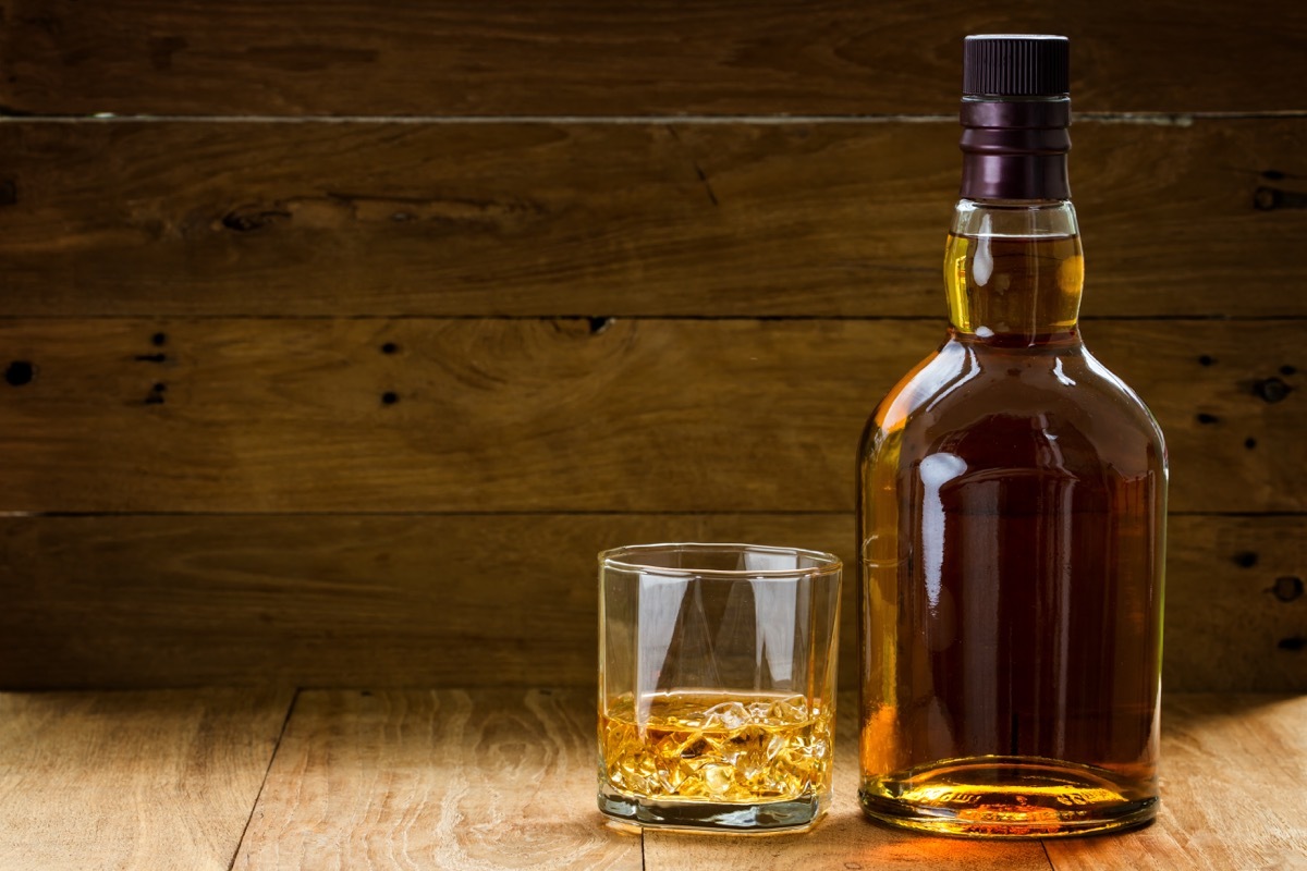 whiskey bottle and glass on wooden table