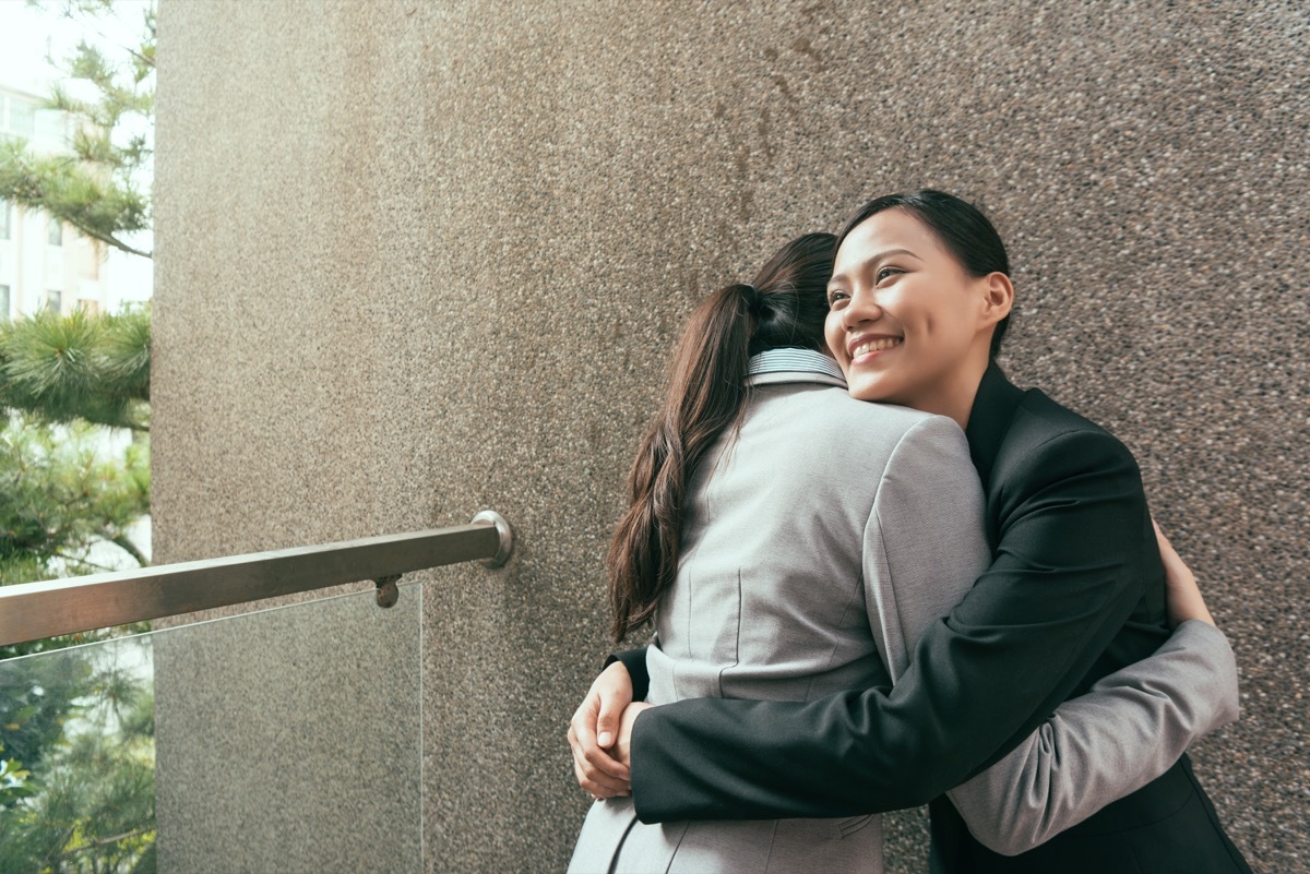 two young asian coworkers talking