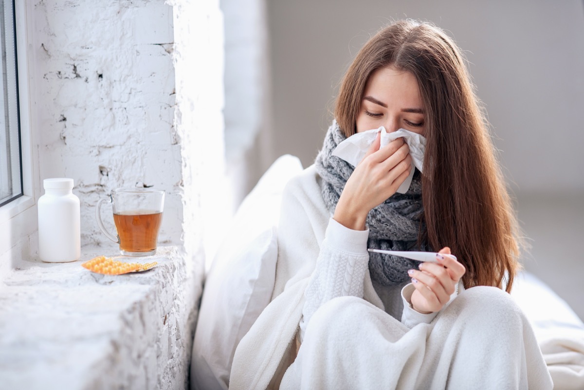 woman with cold blowing her nose