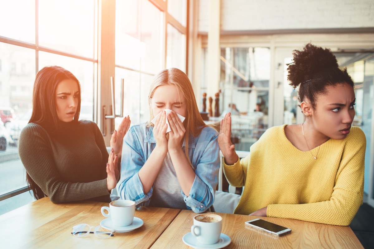 Women trying to avoid their friend's sneeze