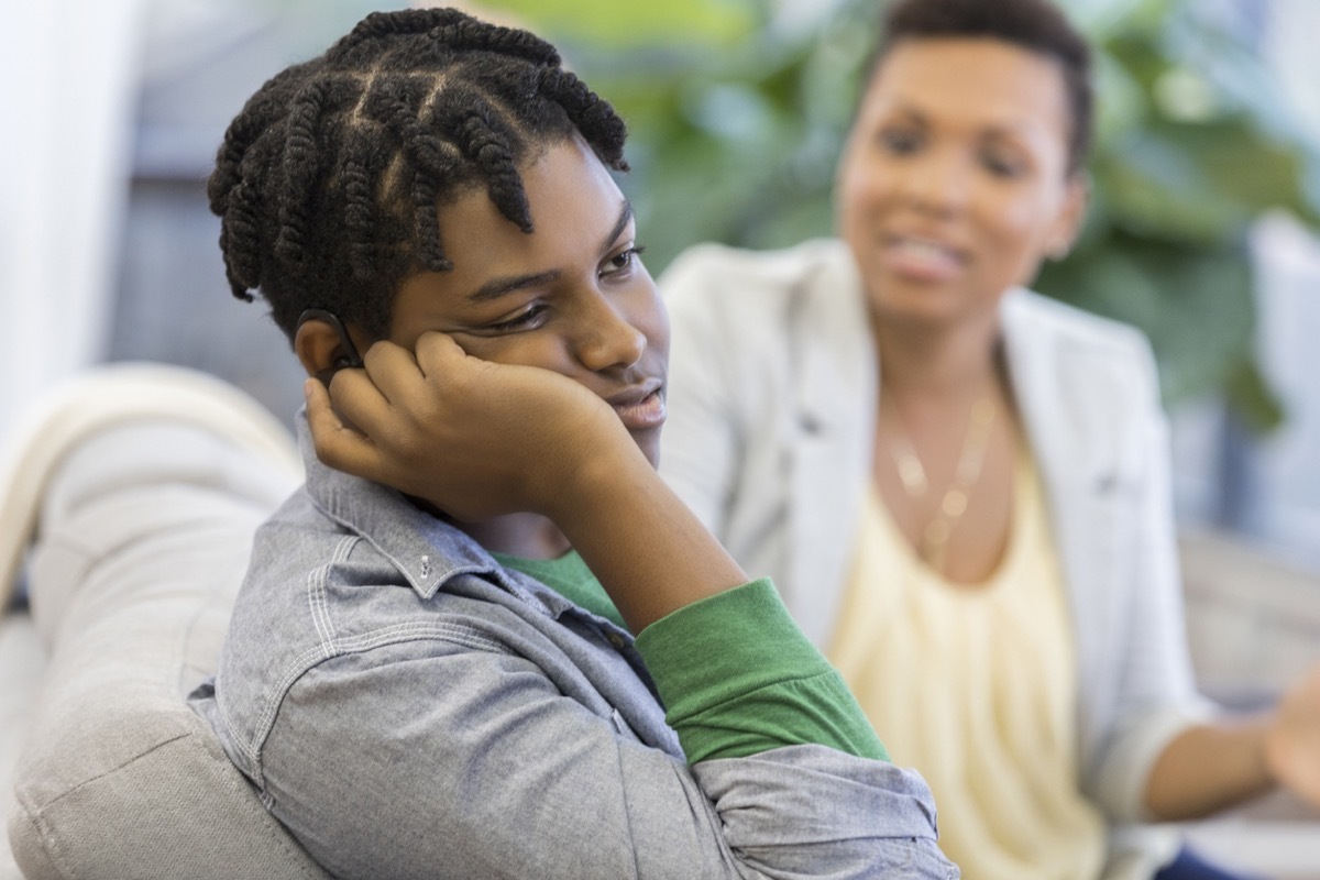 black teen boy ignoring his mom on the couch