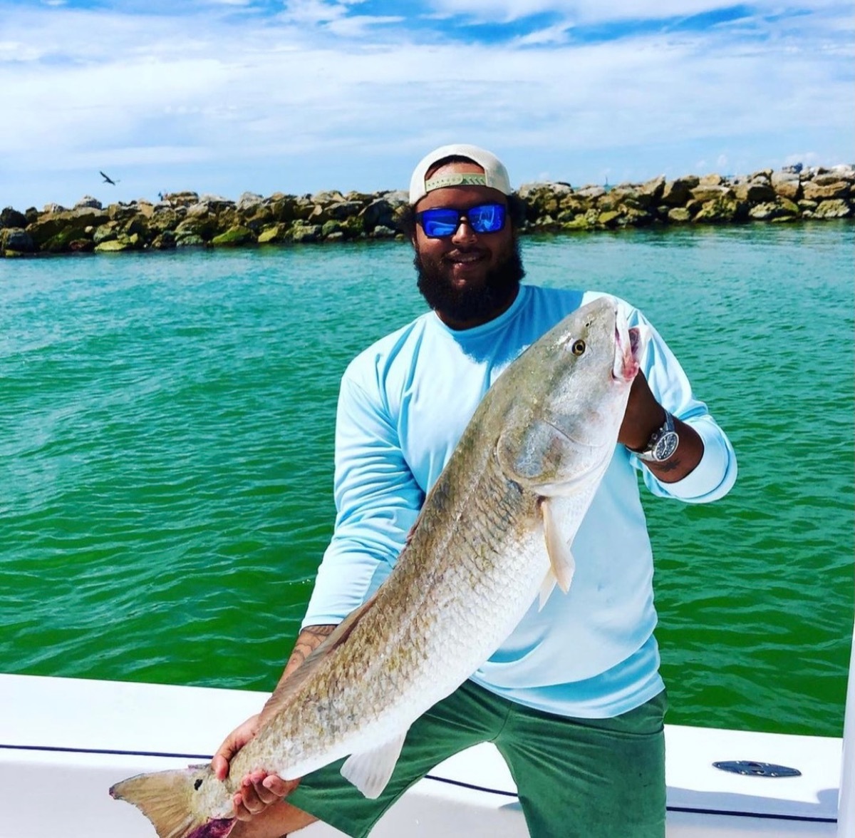 connor cruise on a boat holding a huge fish