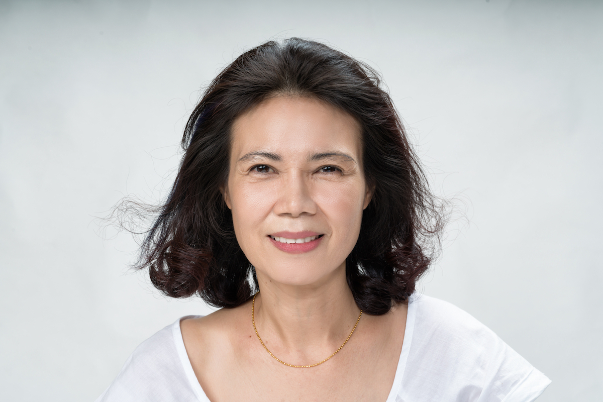 Portrait of beautiful mature asian woman with curly hair style smiling with joyful and charming on white background isolate. Close up happy and cheerful older lady wear white shirt health care concept