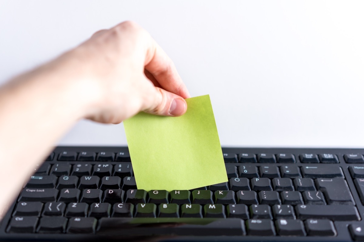 Person Cleaning their Keyboard with a Post-It Note Reuse Disposable Items