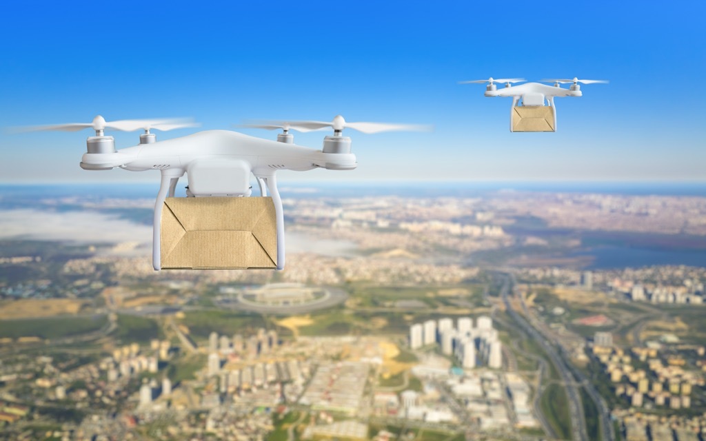 drones delivering packages in the sky above an urban landscape