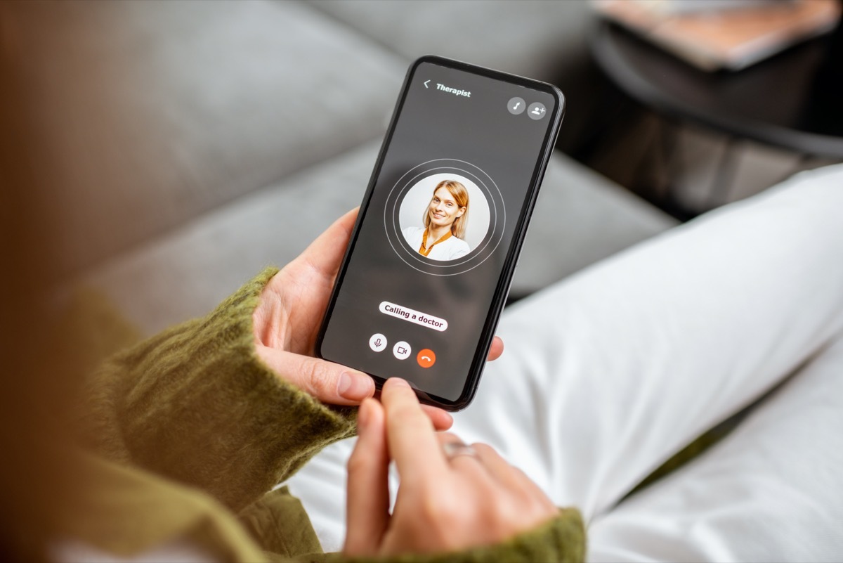 Woman making video call to a doctor using digital tablet, feeling bad at home. Concept of telemedicine and patient counseling online