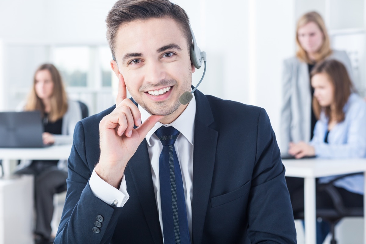 male telemarketer with headset smiles