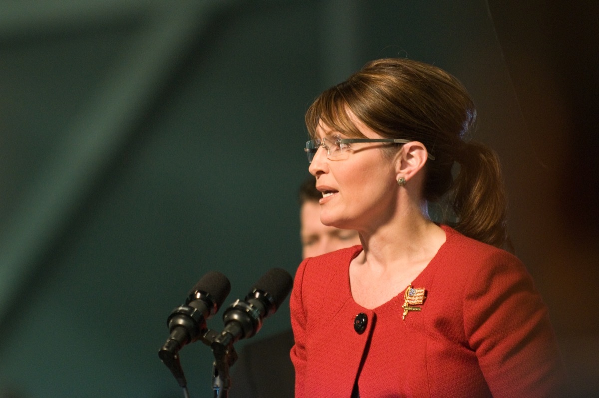 sarah plain speaking at a podium, palin wearing red