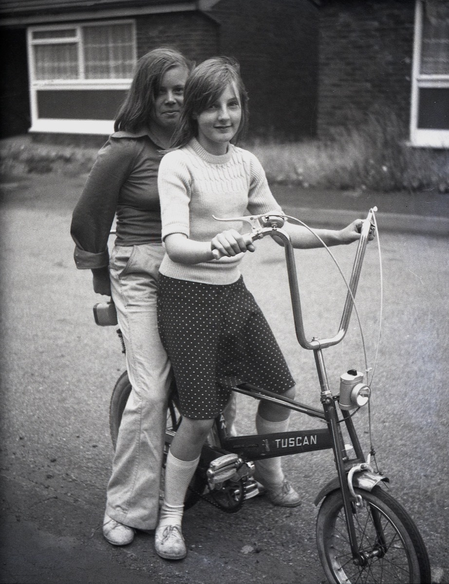 2 girls riding a bike with no helmets, 70s