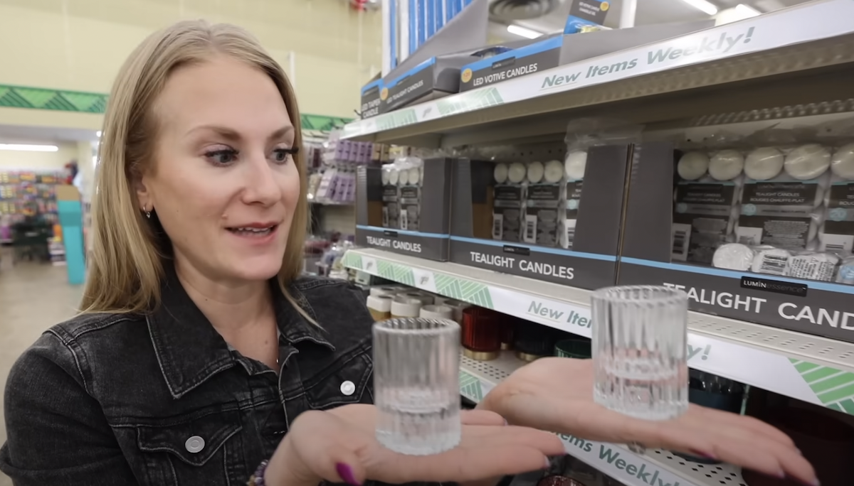 Still from a video of a shopper in Dollar Tree holding up tealight candle holders