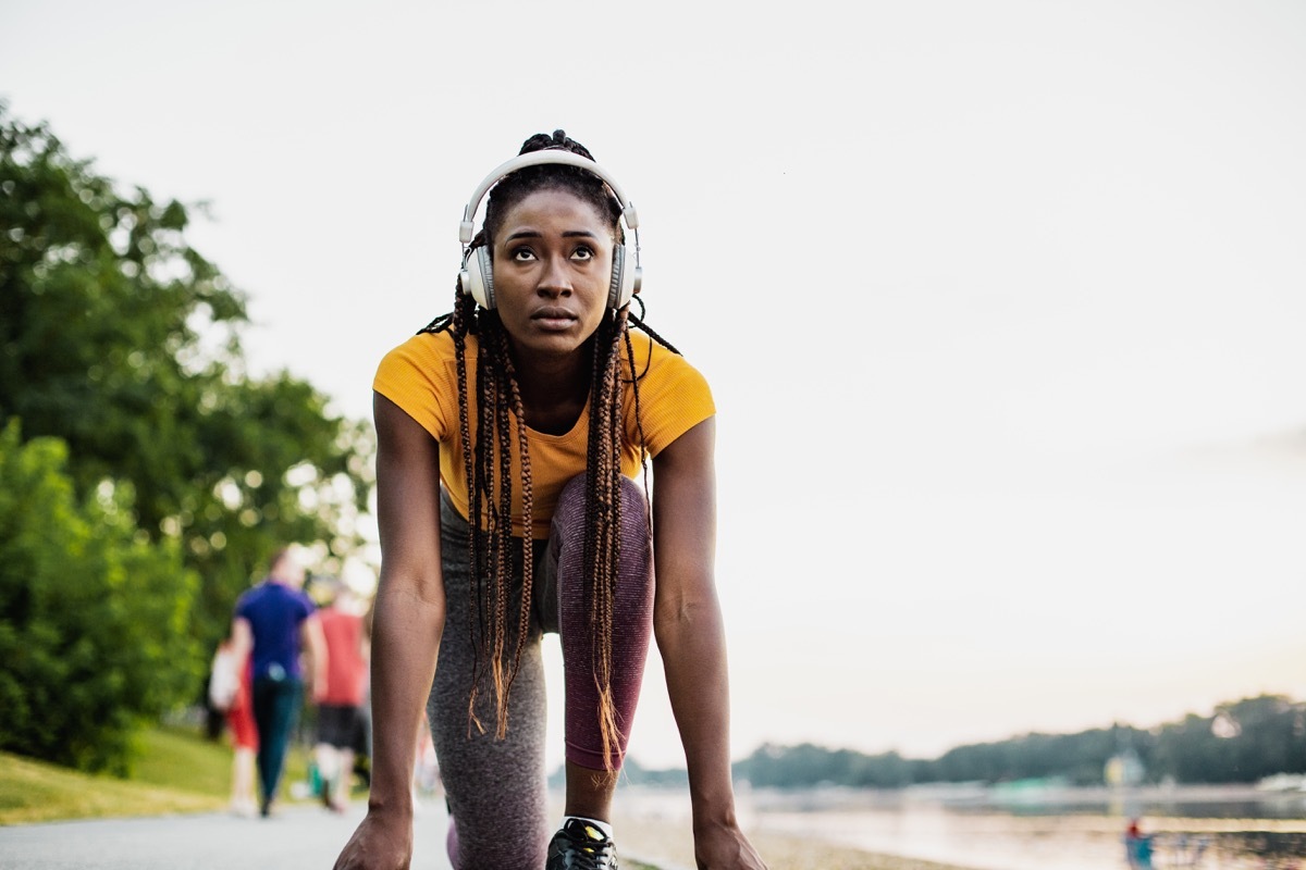 woman with headphones in low start position